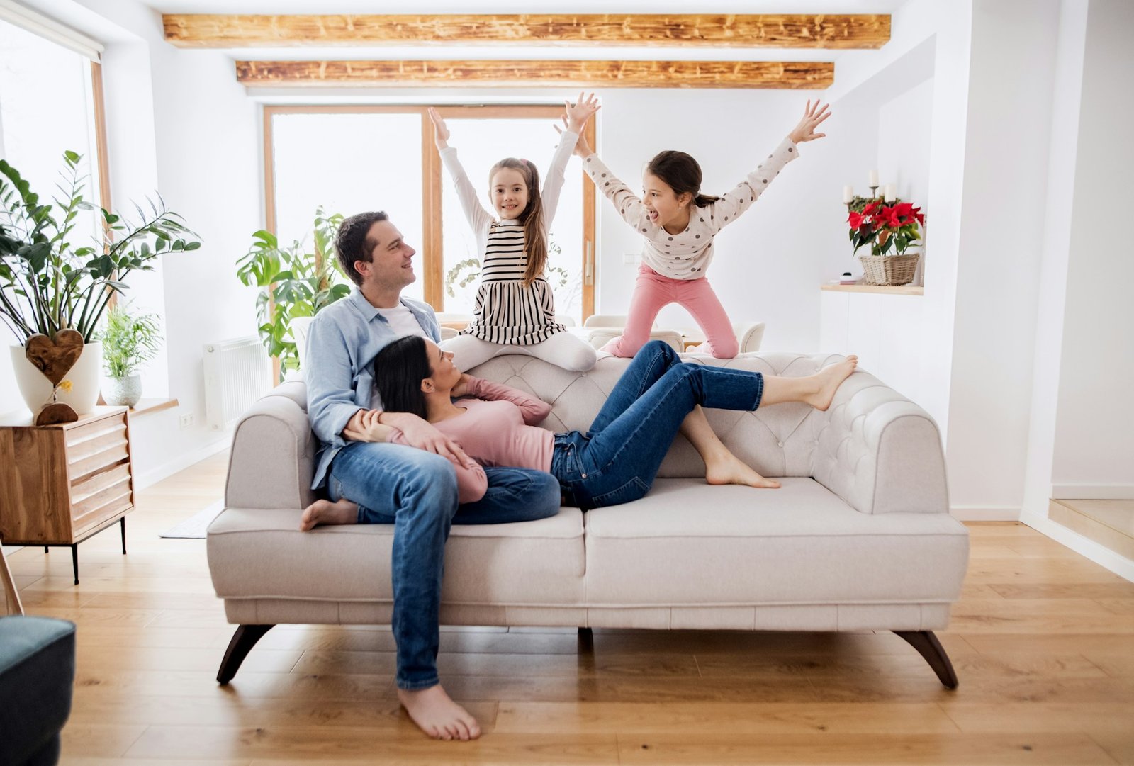 Une famille joue et rit ensemble sur le canapé à la maison