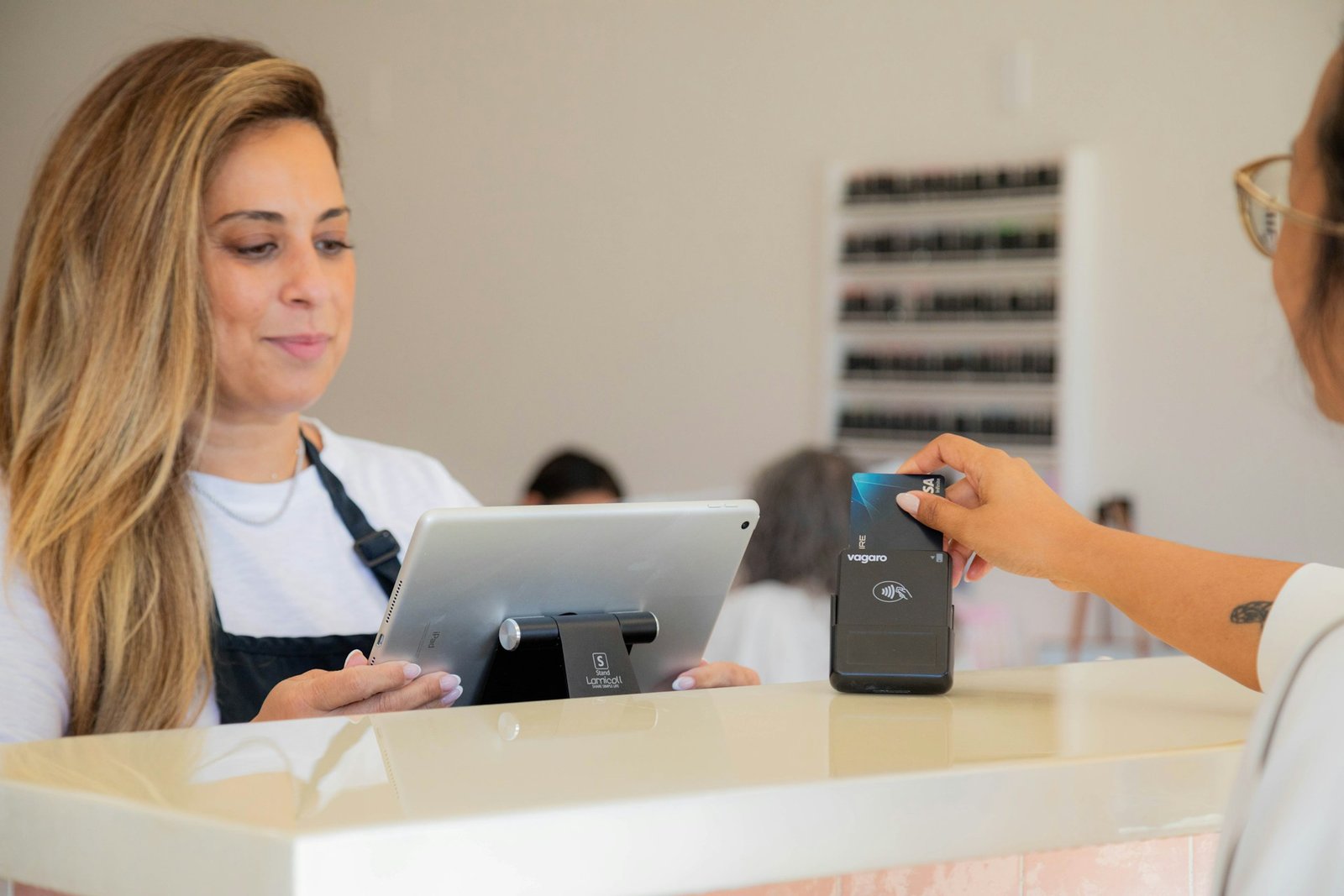 Une cliente règle ses achats par carte bancaire sans contact chez un commerçant