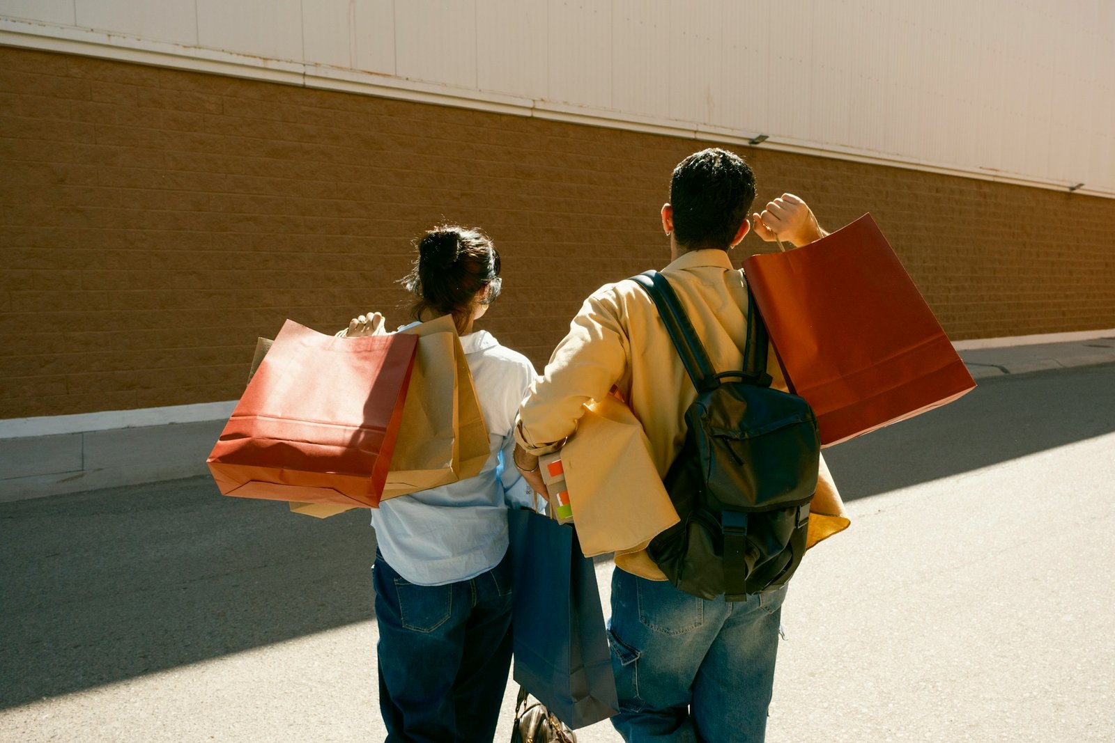 Un couple marche dans la rue, sacs de shopping à la main