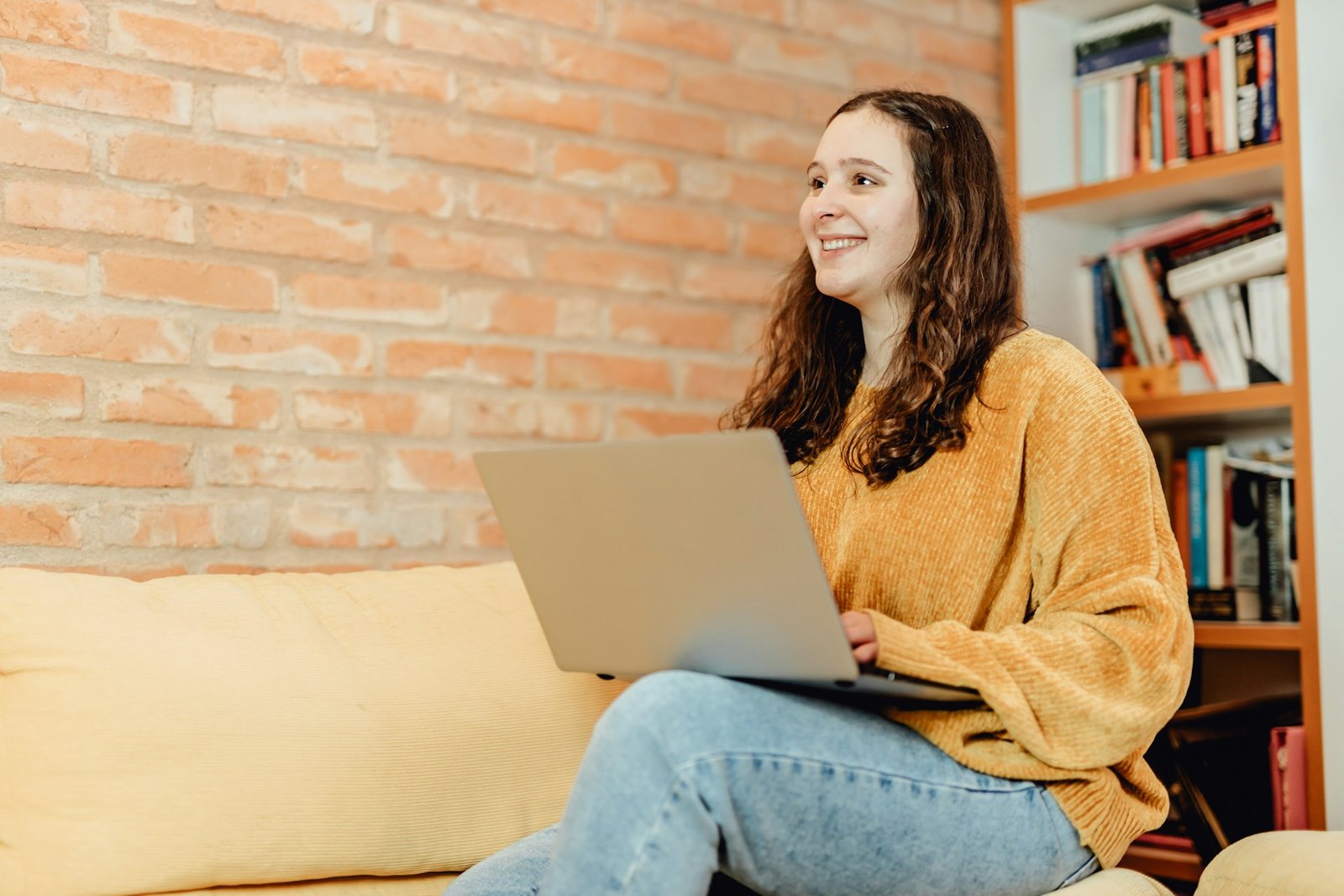 Une femme travaille avec le sourire sur son ordinateur portable à la maison