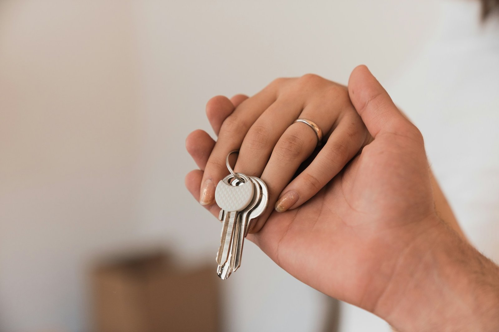 Une main tient un trousseau de clés de maison